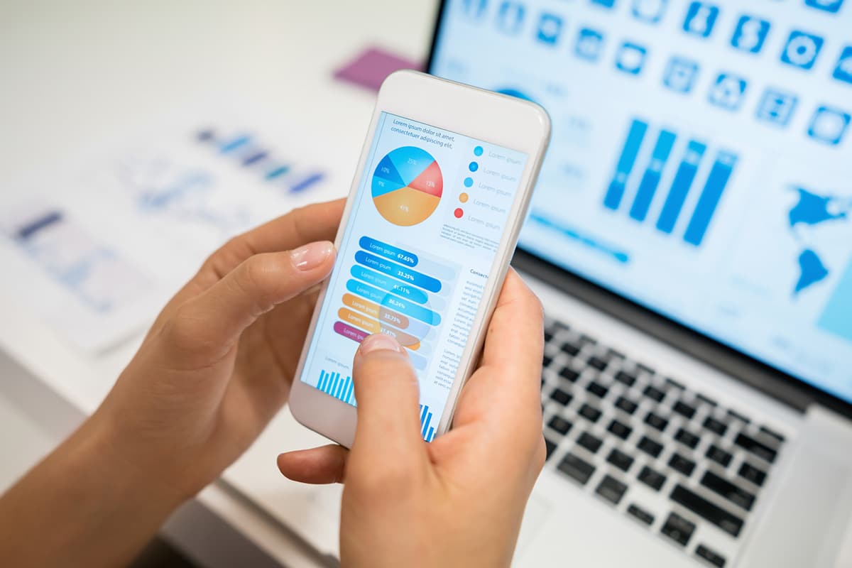 Close up of unrecognizable woman using an app looking at statistics - **DESIGN ON SCREENS WERE MADE FROM SCRATCH BY US**