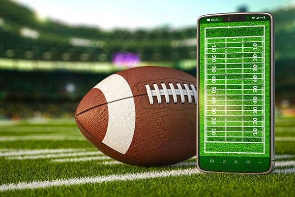 American football app video game on smartphone and betting sport online concept. Mobile phone and american football ball. 3d illustration