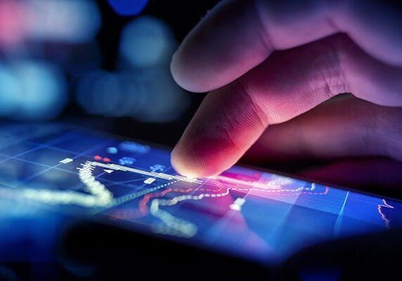 A city businessman using a mobile device to check stocks and market data. Close up shot.